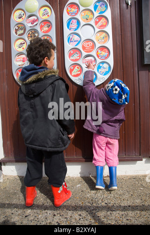 I bambini scegliendo un gelato da un negozio listino prezzi Foto Stock