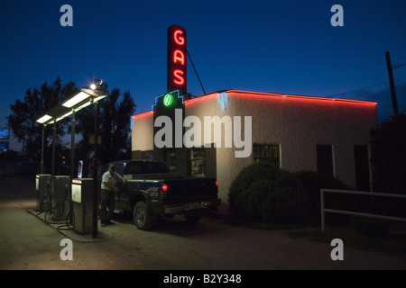 Il Neon della lettura del segno "Gas" come assistente di gas riempie il carrello con benzina a servizio Kensinger, Grand Island, Nebraska Foto Stock