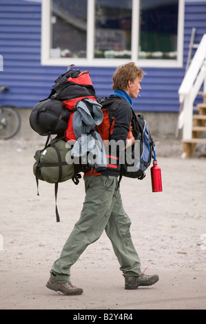 I viaggiatori appesantita con pesanti zaini ad Ilulissat in Groenlandia Foto Stock