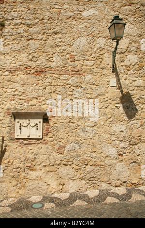Dettaglio del lampione sul ruvido muro di pietra nel quartiere di Santa Cruz, vicino al Castello, Lisbona, Portogallo. Foto Stock