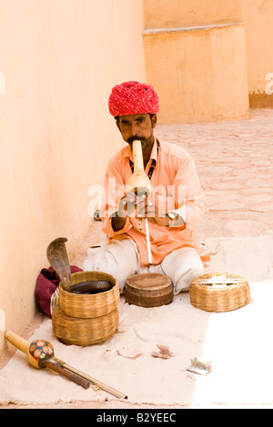 Il serpente incantatore al di fuori della Red Fort, Jaipur, Rajasthan, esegue per i turisti. Foto Stock