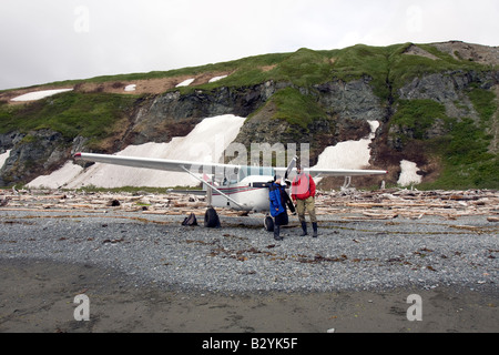 Turista prima di un piccolo aereo su una spiaggia in Katmai National Park & Preserve, Alaska. Foto Stock