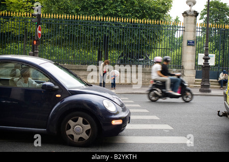 La madre e il bambino da una zebra crossing, in attesa di attraversare una strada molto trafficata Foto Stock