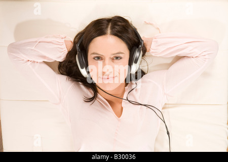 Donna l'ascolto di musica con le cuffie Foto Stock