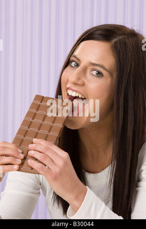 Donna mangiando cioccolato Bar Foto Stock