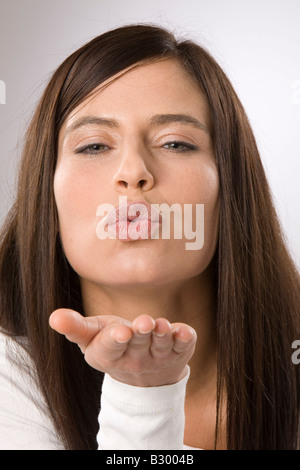 Donna bacio di soffiatura Foto Stock