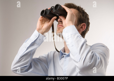 Uomo che utilizza un binocolo Foto Stock