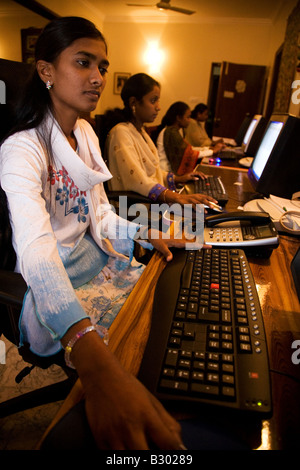 Un dipendente in Bangalore lavora sul suo computer in un ufficio di piccole dimensioni. Foto Stock