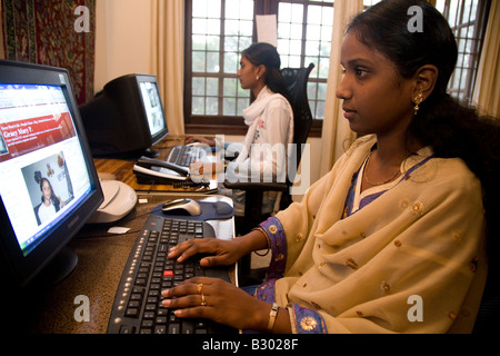 Un dipendente in Bangalore lavora sul suo computer in un ufficio di piccole dimensioni. Foto Stock