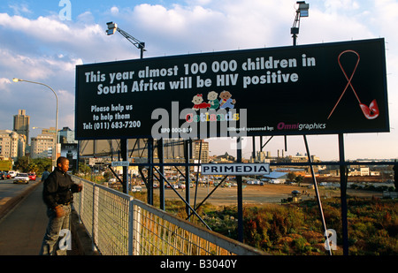 Uomo in piedi di fronte all Aids awareness billboard. Johannesburg, Sud Africa. Foto Stock