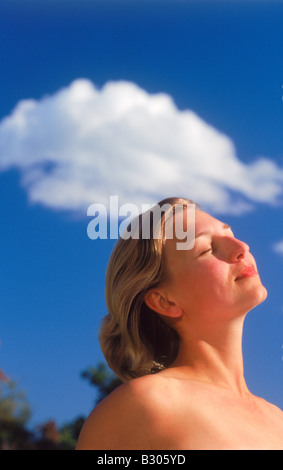 Donna svedese a prendere il sole sotto passando il cloud e il blu del cielo Foto Stock