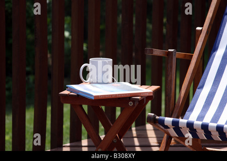 Una rilassante estate tè del mattino e prenota sul ponte Foto Stock