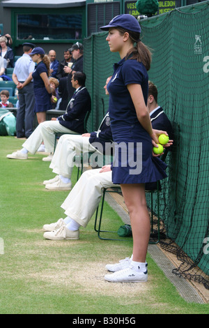 Ragazza a sfera e la linea di arbitri sul Centre Court di Wimbledon Tennis Championship in Inghilterra Foto Stock