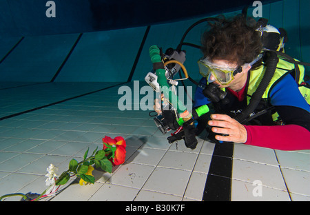 Donna scuba diver pratiche di fotografia subacquea in piscina Foto Stock