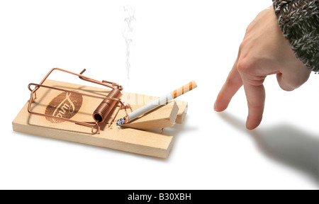Dita femmina di intrufolarsi di fumare una sigaretta in un mousetrap Foto Stock