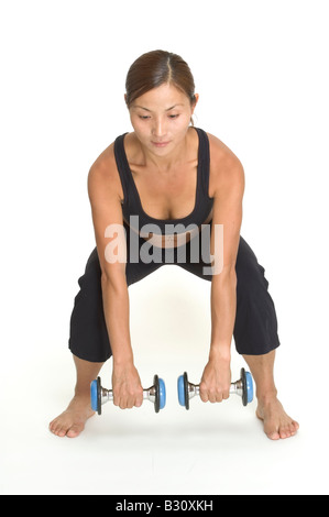 Una femmina di istruttore di fitness dimostra la posizione di partenza del dumbbell deadlift Foto Stock