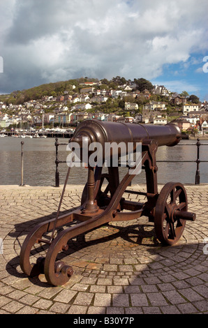 Un vecchio cannone sul lungomare a Dartmouth con la città di Kingswear oltre Foto Stock