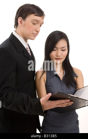 Un uomo di affari e donna di guardare al di sopra di un contratto in un blocco appunti. Isolato su sfondo bianco Foto Stock