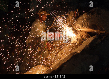 Uomo arabo il taglio di metallo senza maschera protettiva Foto Stock