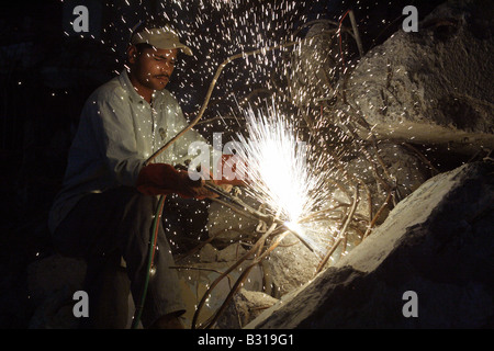 Uomo arabo il taglio di metallo senza maschera protettiva Foto Stock