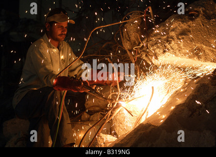 Uomo arabo il taglio di metallo senza maschera protettiva Foto Stock