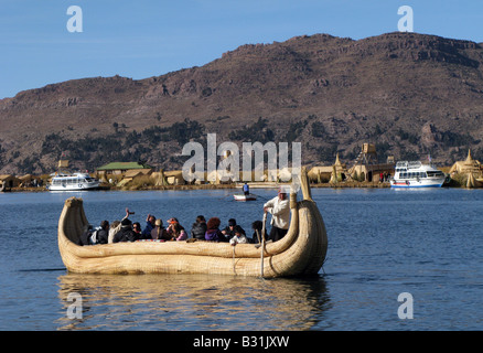 Uros cittadini e turisti sulla barca reed on self-stile reed flottante isole del Lago Titicaca, Perù Foto Stock