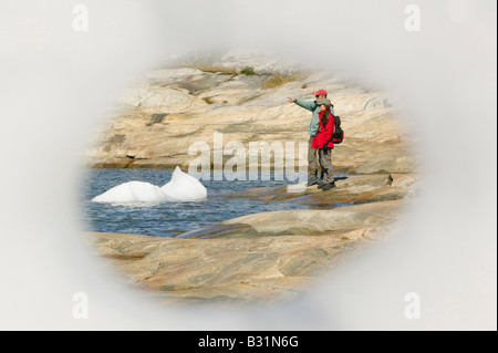 Guardando attraverso un foro in un iceberg a Ilulissat in Groenlandia con gli iceberg da Jacobshavn icebergs dietro Foto Stock