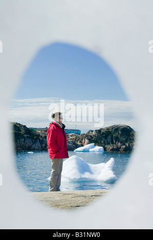 Guardando attraverso un foro in un iceberg a Ilulissat in Groenlandia con gli iceberg da Jacobshavn icebergs dietro Foto Stock