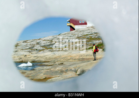 Guardando attraverso un foro in un iceberg a Ilulissat in Groenlandia con gli iceberg da Jacobshavn icebergs dietro Foto Stock