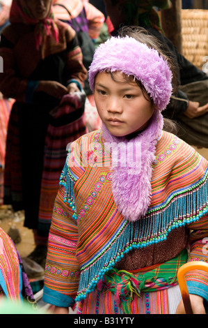 Un giovane fiore ragazza Hmong a piedi attraverso Bac Ha mercato Nord Vietnam Foto Stock