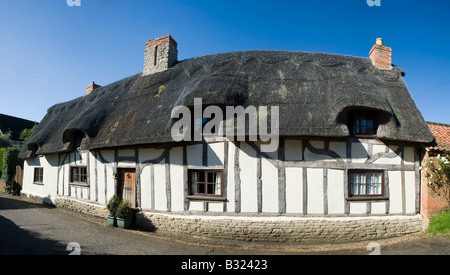 Cottage con tetto in paglia in un villaggio inglese Foto Stock