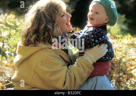 La madre a giocare con la sua giovane bambino in legno di autunno Foto Stock