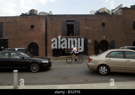 Ciclista manovre attraverso il traffico in Red Hook quartiere di Brooklyn a New York Foto Stock