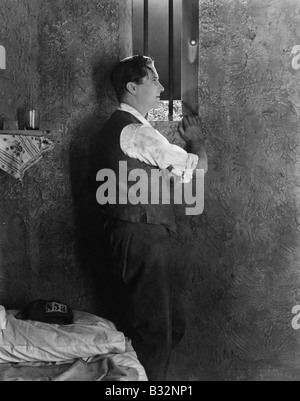Uomo alla finestra della cella di prigione Foto Stock