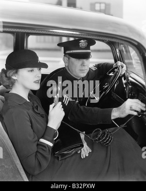 Donna che utilizza la radio in macchina con la polizia Foto Stock
