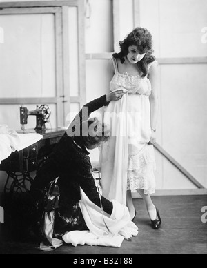 Profilo di una femmina di adattare la misurazione di una giovane donna in un negozio nuziale Foto Stock