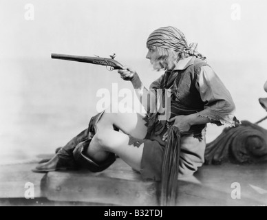 Profilo di una giovane donna tenendo un flintlock pistillo in un vestito dei pirati Foto Stock