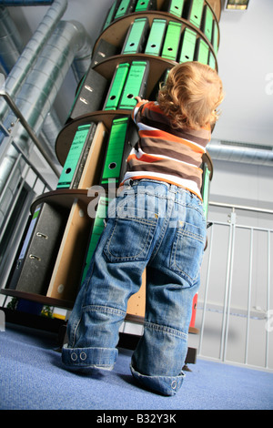 Piccolo Ragazzo davanti a una cartella rack di stoccaggio in ufficio Foto Stock