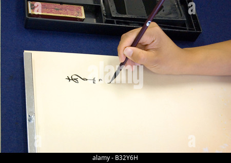 Giapponese di alta scuola studente practice calligraphy Foto Stock