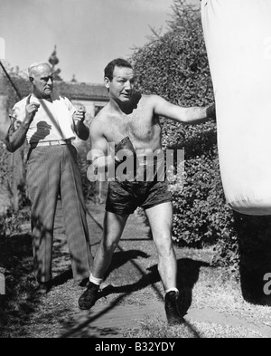 Atleta con il suo allenatore lavorando su un sacco da boxe Foto Stock