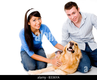 Una giovane coppia corsa il loro cane - girato in studio su sfondo bianco Foto Stock