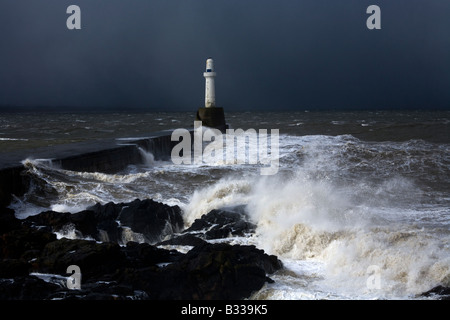 Le difficili condizioni atmosferiche le percosse uno dei fari segnando l'ingresso al porto di Aberdeen, Aberdeenshire, Scozia Foto Stock