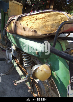 Vecchio danneggiato scooter ciclomotore in strada di Sun Foto Stock