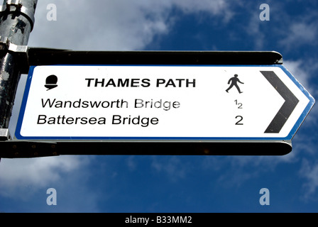 Bianco e nero thames path segno indicante le direzioni a Wandsworth bridge e ponte di Battersea, a Wandsworth, a sud-ovest di Londra. Foto Stock