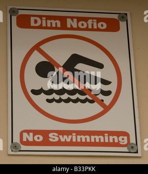 Bi-lingue Welsh/avviso inglese che vieta il nuoto in Porthcawl Harbour S Galles Foto Stock