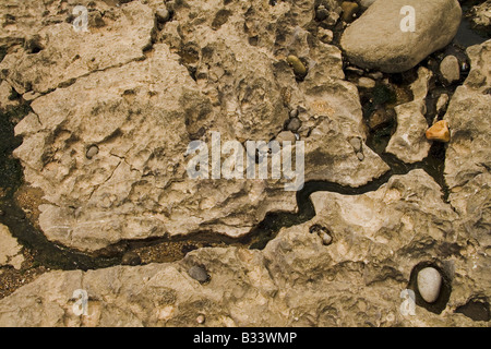 Acqua fresca in esecuzione attraverso un canale di roccia al mare sulla spiaggia di Porthcawl Foto Stock