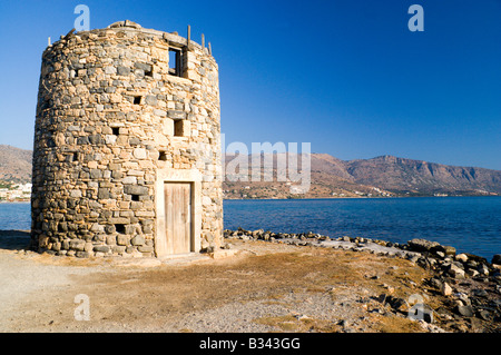 Vecchio mulino a vento abbandonato sulla strada rialzata che conduce a kolokitha penisola elounda Creta Grecia Foto Stock