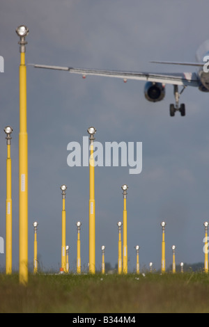 Aereo commerciale a breve avvicinamento finale all'Aeroporto Heathrow di Londra con luci di atterraggio in primo piano. Foto Stock