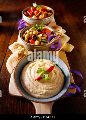 Parte del cibo - dalla parte anteriore - Houmous, ceci, insalata marinata di Mediterraneo peperoni arrosto Foto Stock