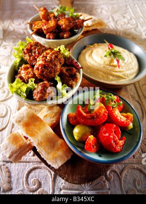 Il barbecue party cibo - dalla parte anteriore - Sun Blushed Pomodori, agnello, Kofta Houmous, Mini marinati spiedini di pollo con pane pitta Foto Stock